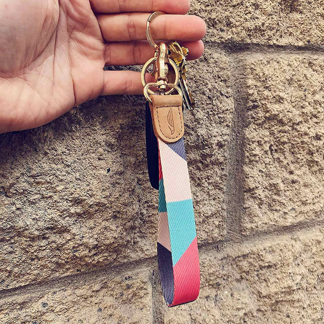 People holding pink mint cream gray hand wrist lanyard with keys on the hand