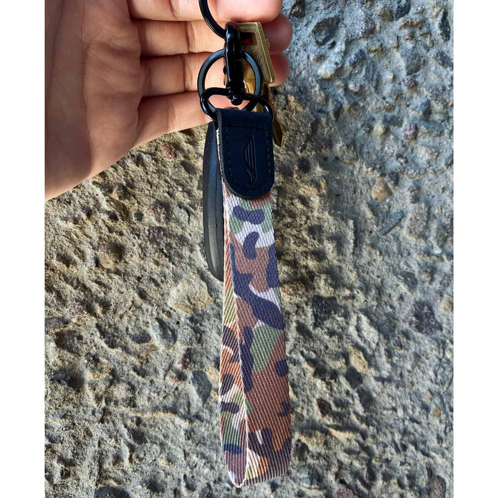 Camouflage wrist lanyard with keys on hand stone background