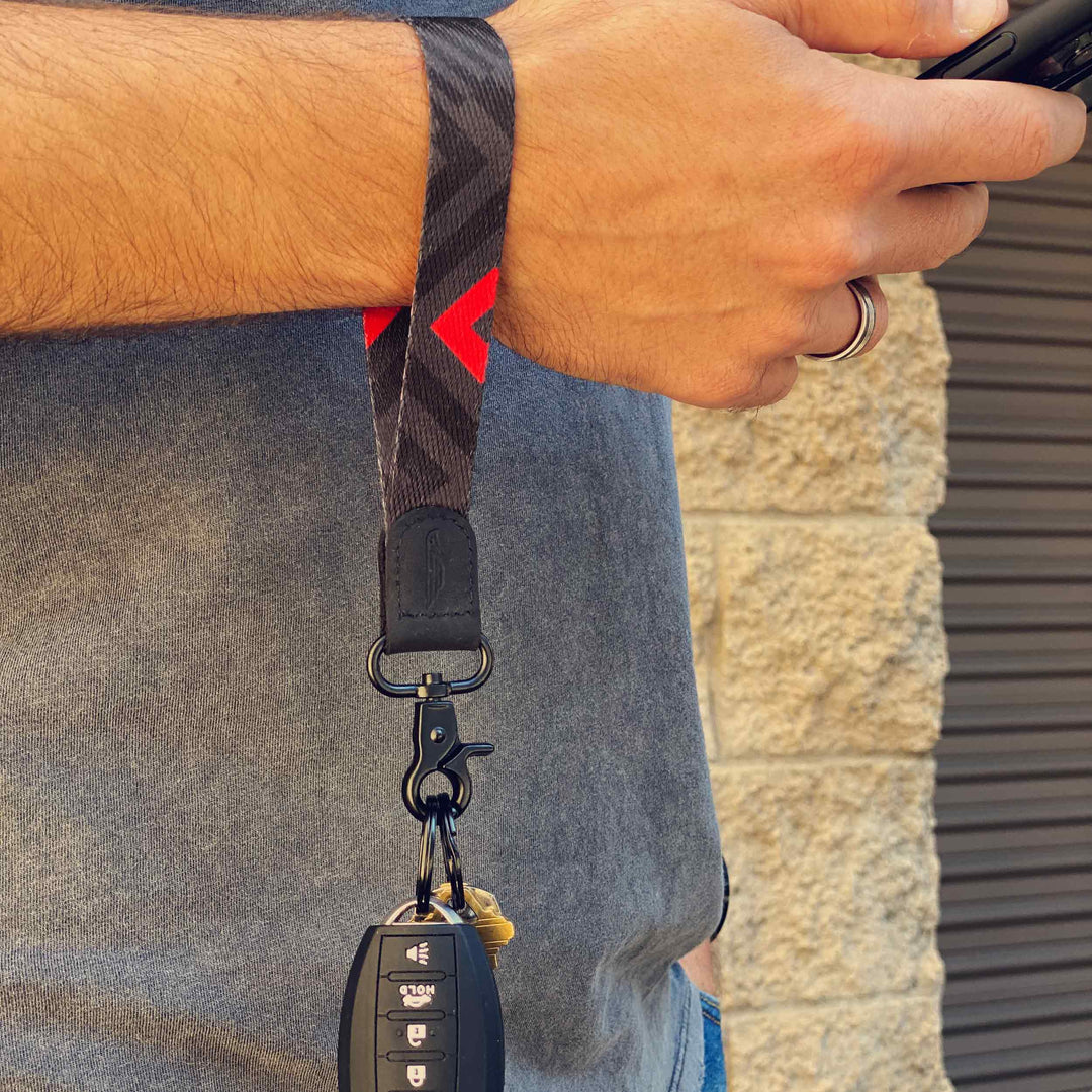 Man wears black and red cool wrist lanyard to carrying keys