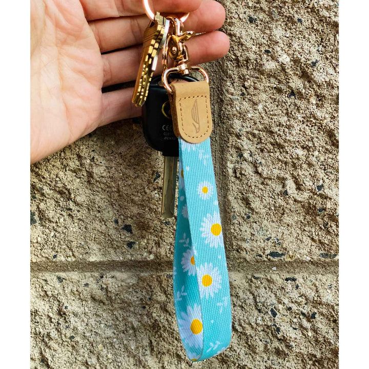 Daisy patterned blue hand wrist lanyard with keys on the hand