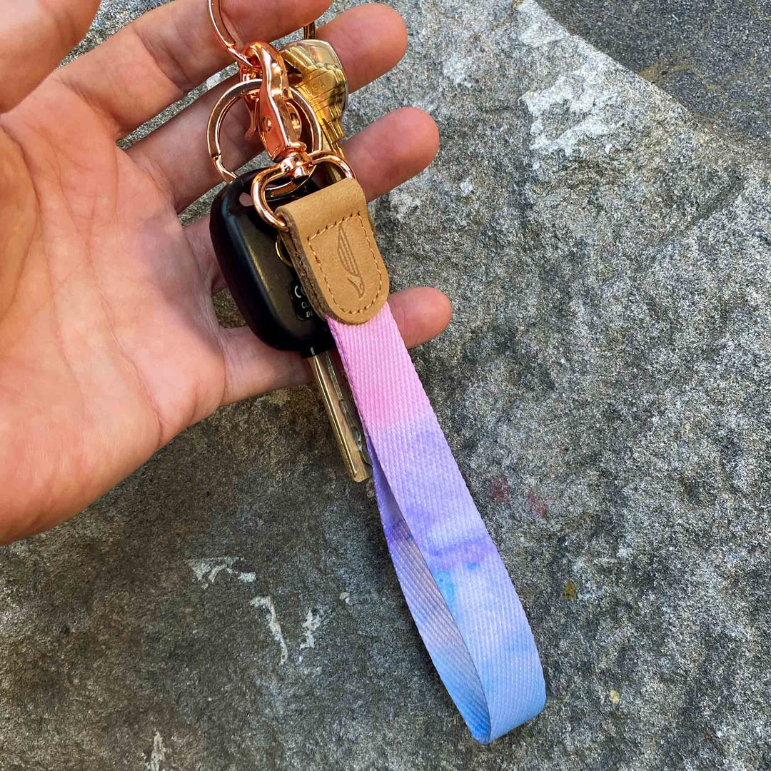 Pink violet blue colored hand wrist lanyard with keys on the hand stone background