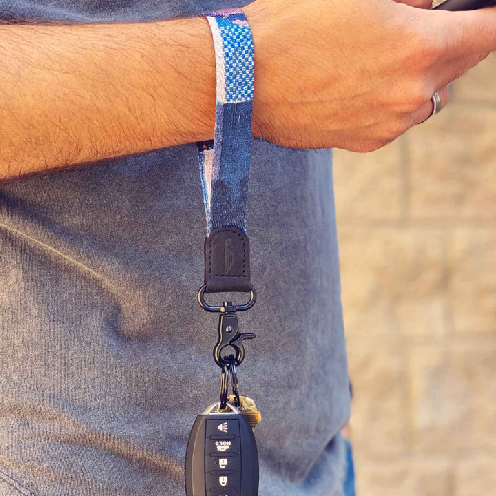 Man wears navy white cool wrist lanyard to carrying keys