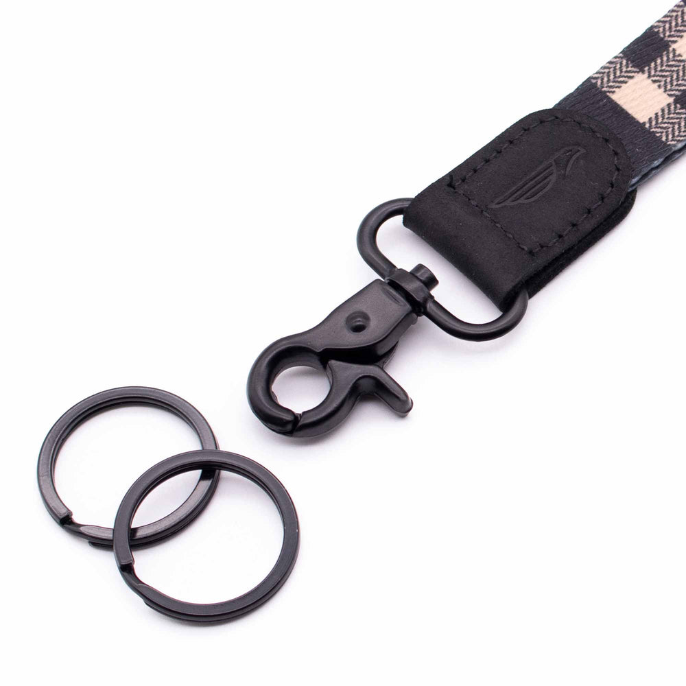 Close up black lanyard with 2 metal key rings black leather black cream fabric