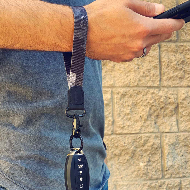 Man wears black and gray cool wrist lanyard to carrying keys