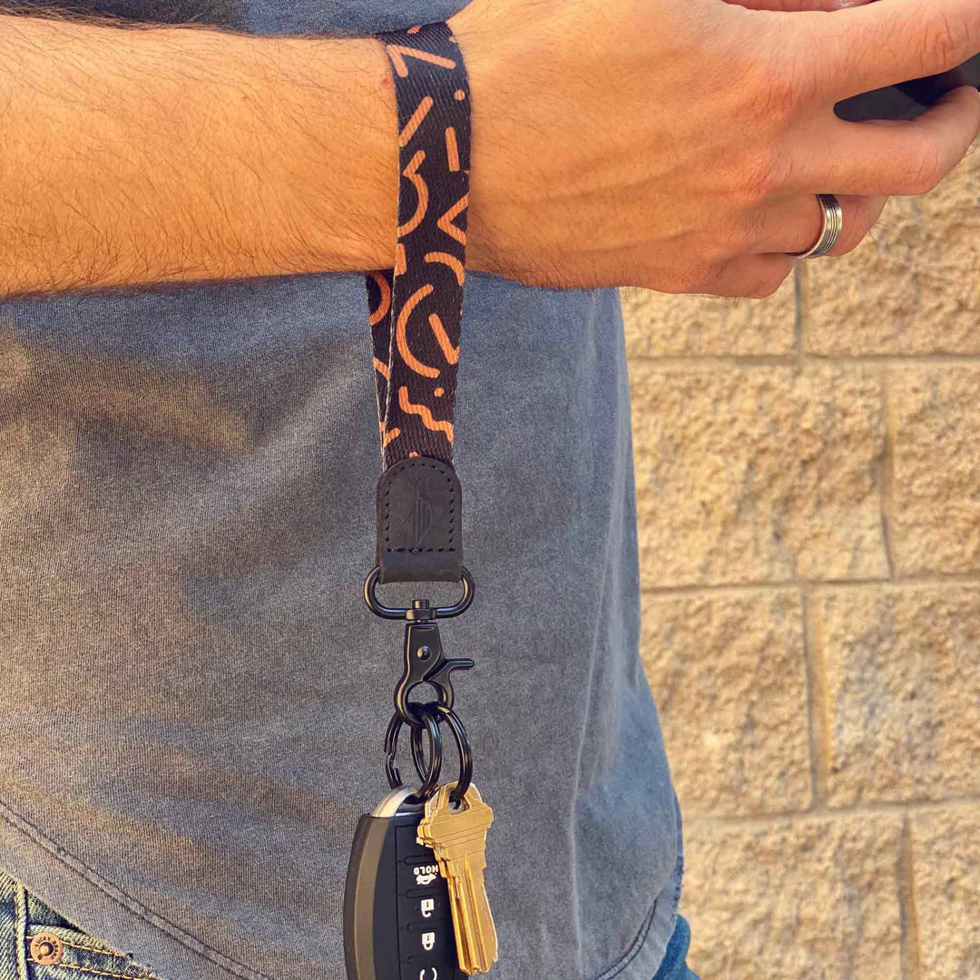 Man wears black and brown cool wrist lanyard to carrying keys